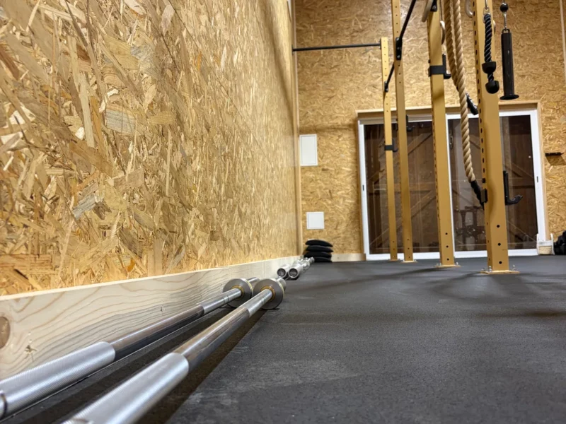 Zone crosstraining du Training Lodge : barres d'haltérophilie olympiques et rack
